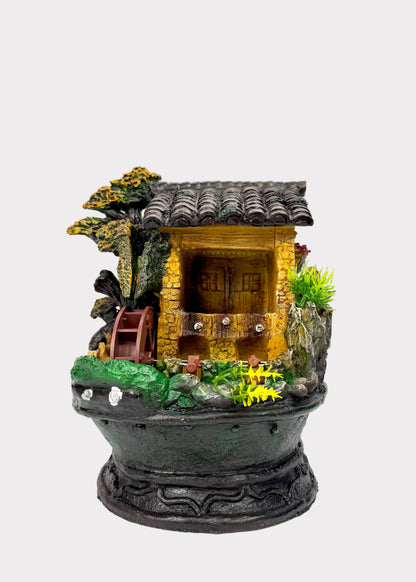 Feng Shui water fountain with miniature house and decorative elements on a white background