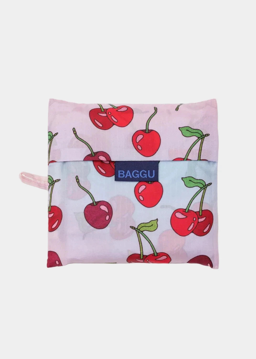 Reusable bag with cherry pattern and 'Baggu' brand logo on a light pink background