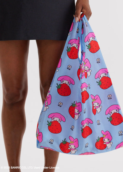 Reusable bag with cartoon character and strawberry pattern held by a person