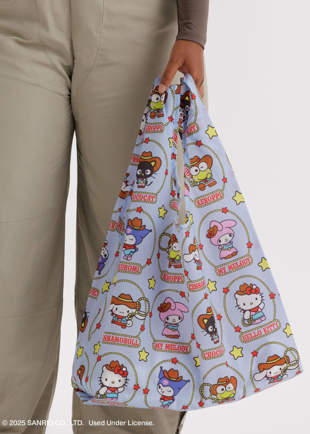 Person holding a colorful bag with cartoon character design on a plain background