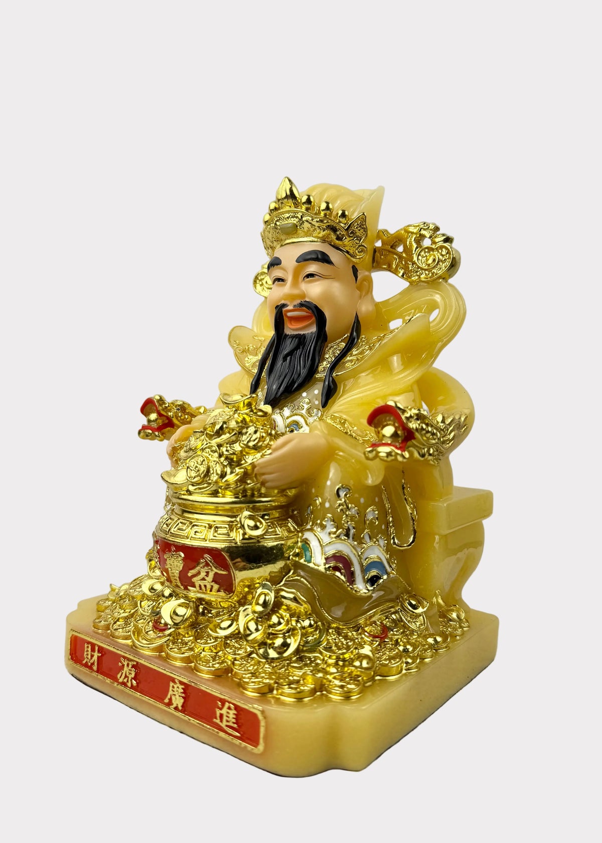 A golden Chinese deity figurine, likely representing Wealth (Fu Kun), seated on a base with Chinese characters. The figurine is primarily gold with a pale yellow body, a black beard, and small red accents.