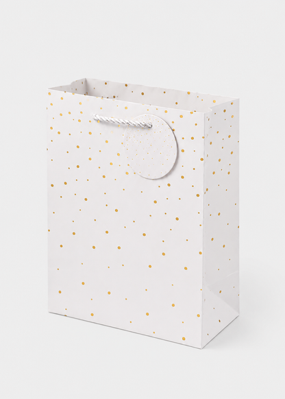 White gift bag with gold polka dots on a white background