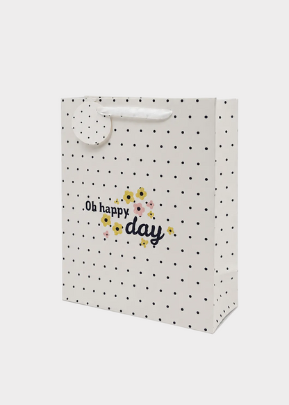 Polka dot gift bag with 'Oh happy day' text and floral design on a white background