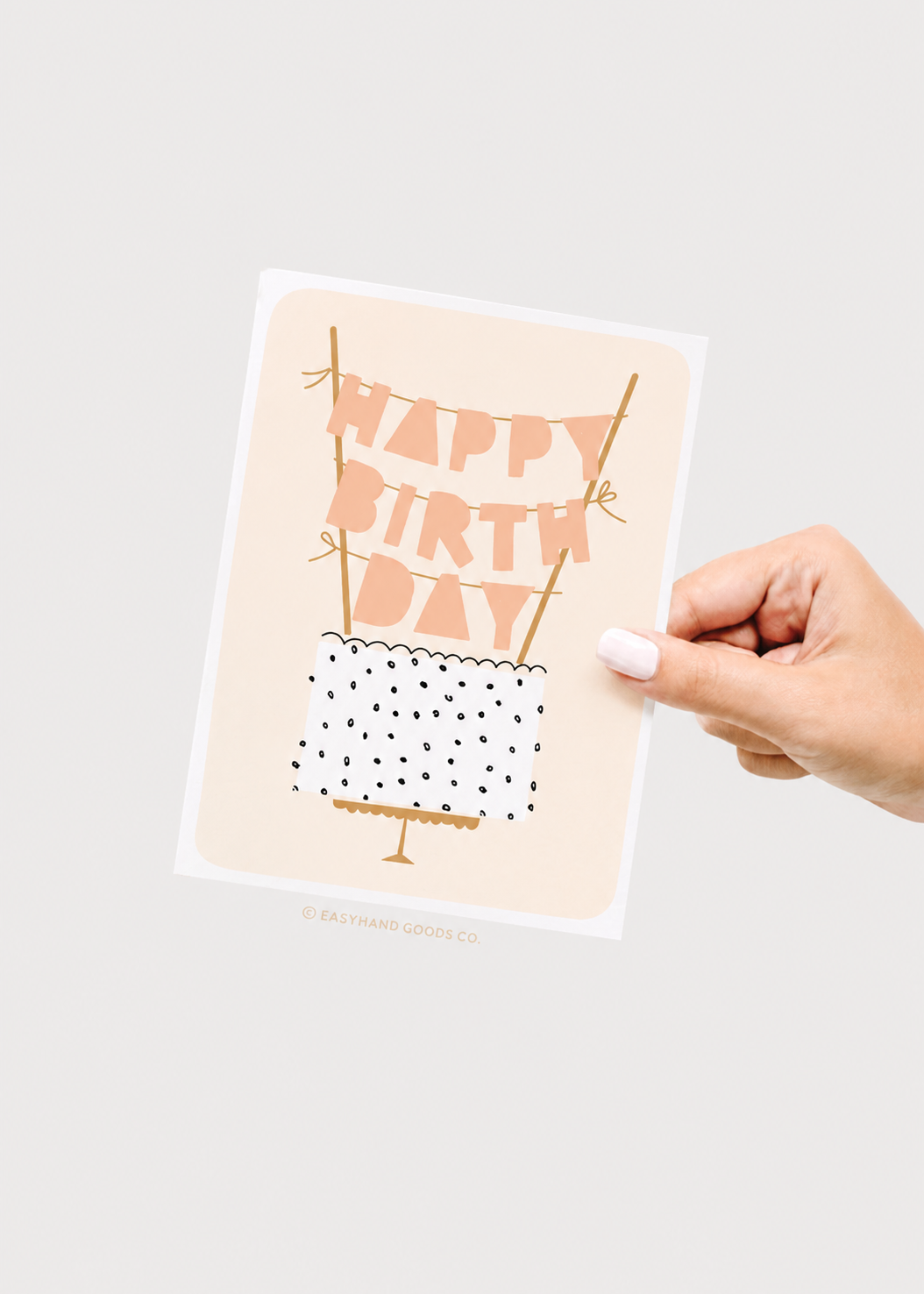 Hand holding a birthday card with 'Happy Birthday' text on a plain background
