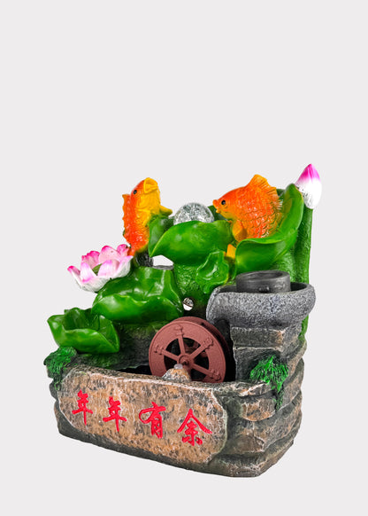 Decorative fountain with fish and plants on a white background