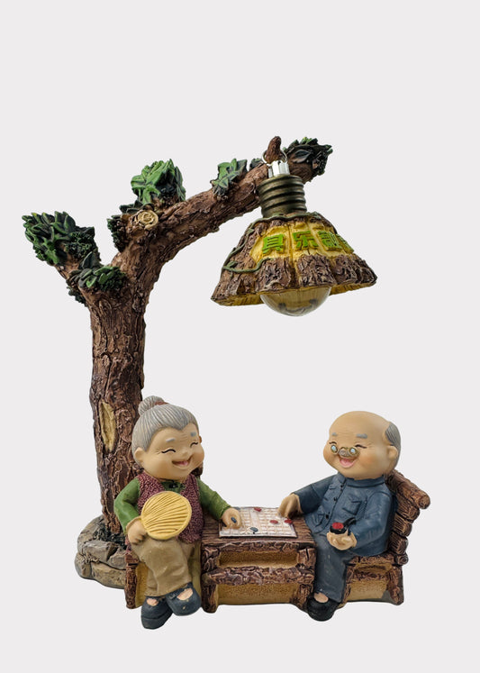 Grandparents Playing Chess Under Tree Lamp Figurine