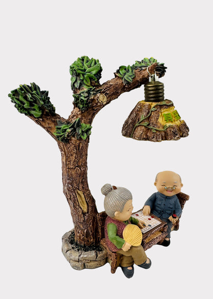 Grandparents Playing Chess Under Tree Lamp Figurine