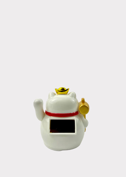A white ceramic lucky cat figurine with a black rectangular screen on its belly, a red collar, and gold accents including a raised paw, a small ingot on its head, and a golden mallet, set against a plain white background.