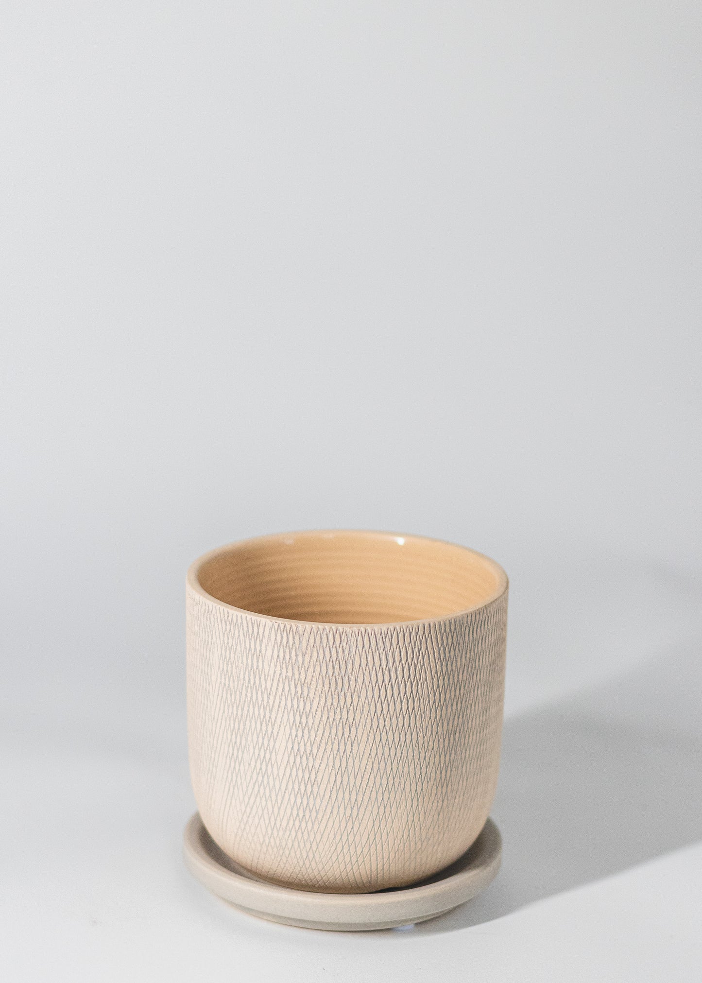 criss-cross etching on the planter in biege and gray tones