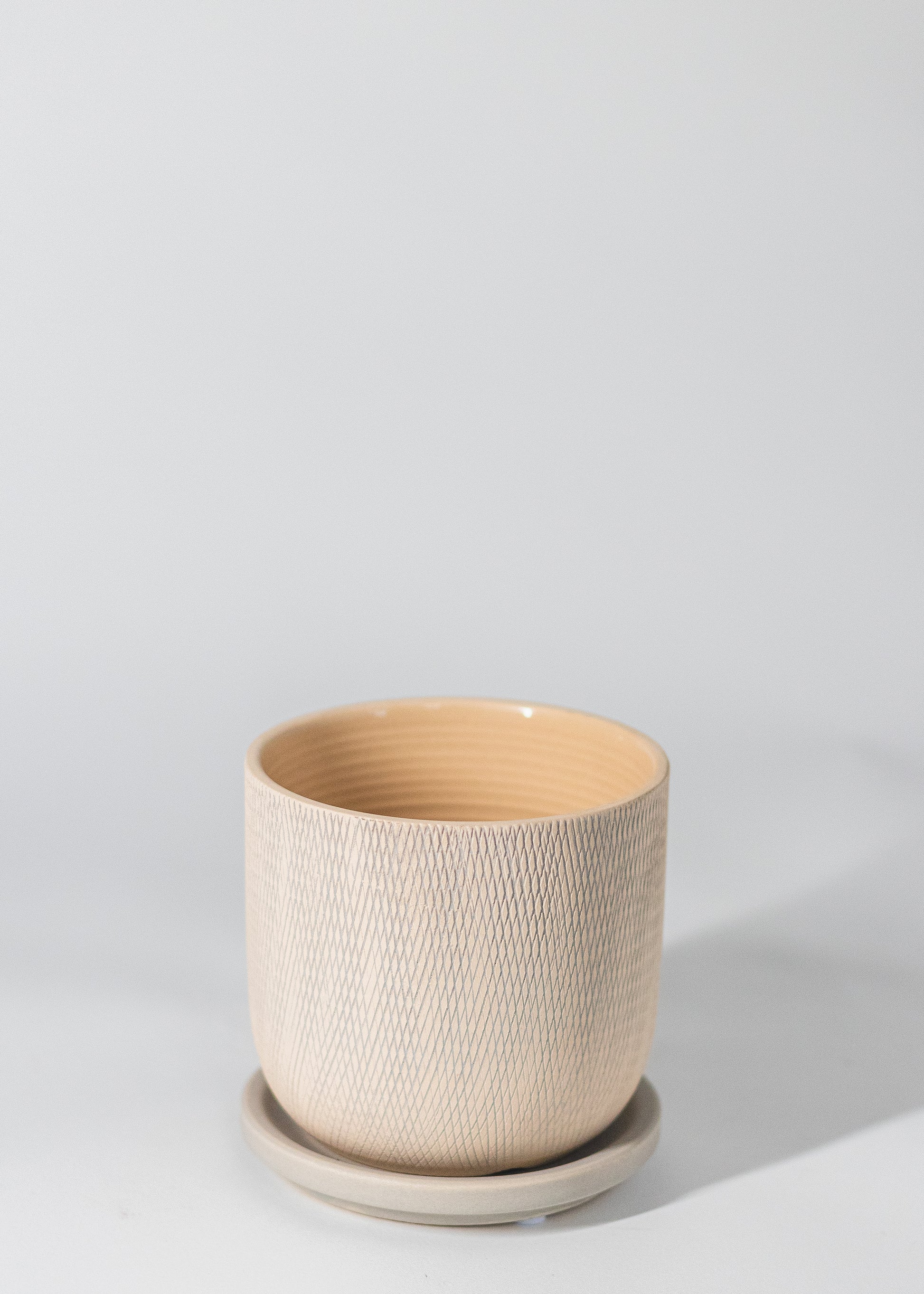 criss-cross etching on the planter in biege and gray tones
