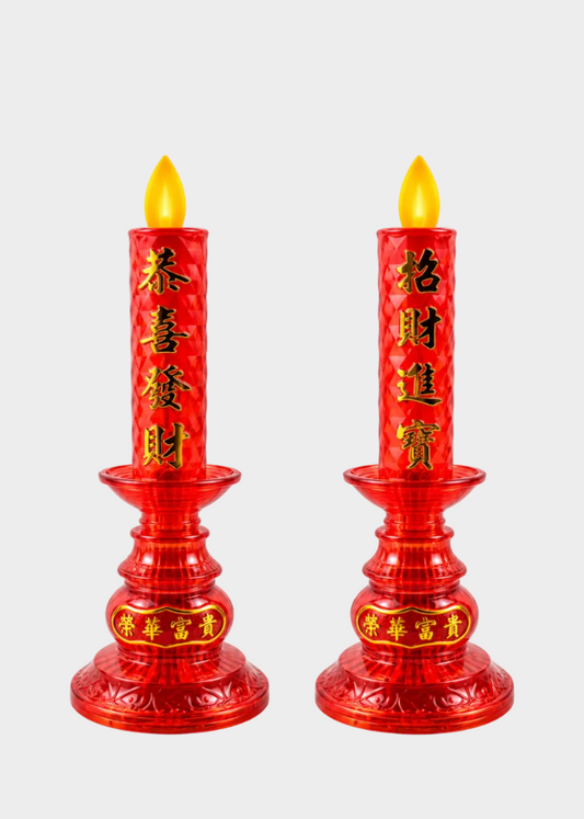Two red plastic candle holders with yellow flame-shaped tops and gold Chinese characters, shown side by side on a light gray background.