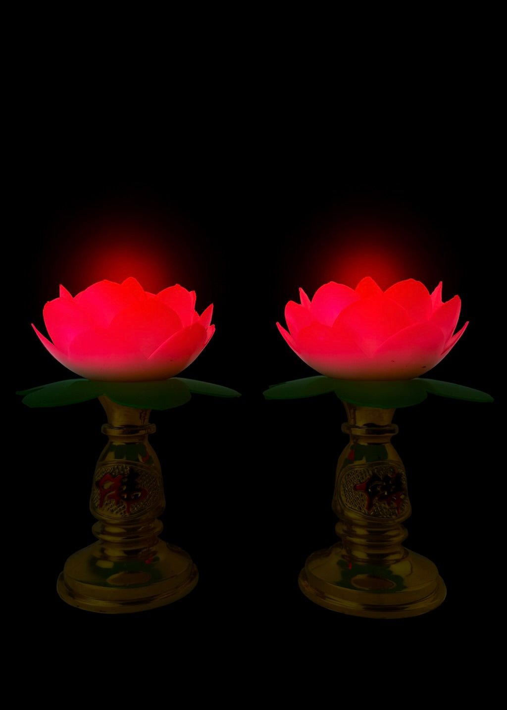 Two red glowing lotus flowers on stands against a black background