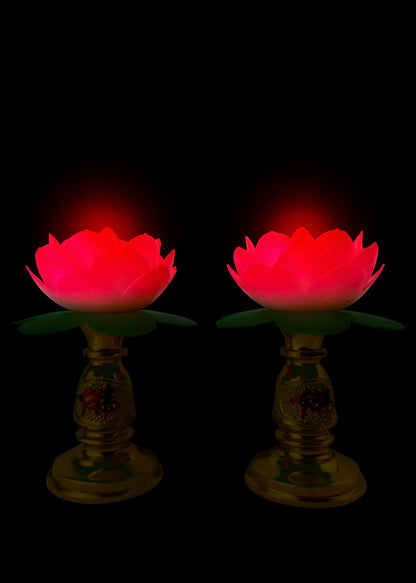 Two red glowing lotus flowers on stands against a black background