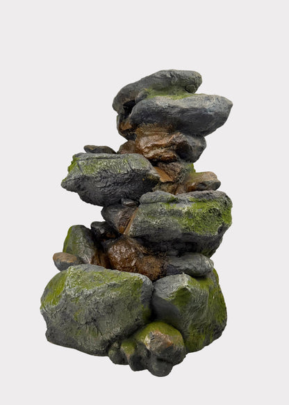 Stack of decorative rocks with green moss on a white surface
