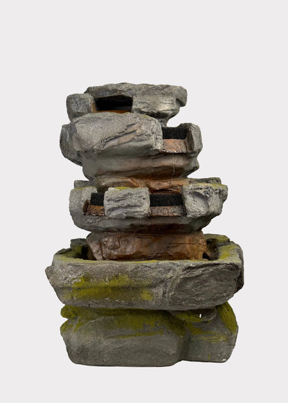 Stack of stone Fountain on a white surface with a blurred background