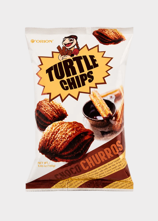 A bag of Orion Turtle Chips Chocolate Churros on a light gray background. The packaging is primarily white with a large yellow starburst logo, brown chocolate-chip imagery, and orange text reading 'CHOCOLATE CHURROS'.
