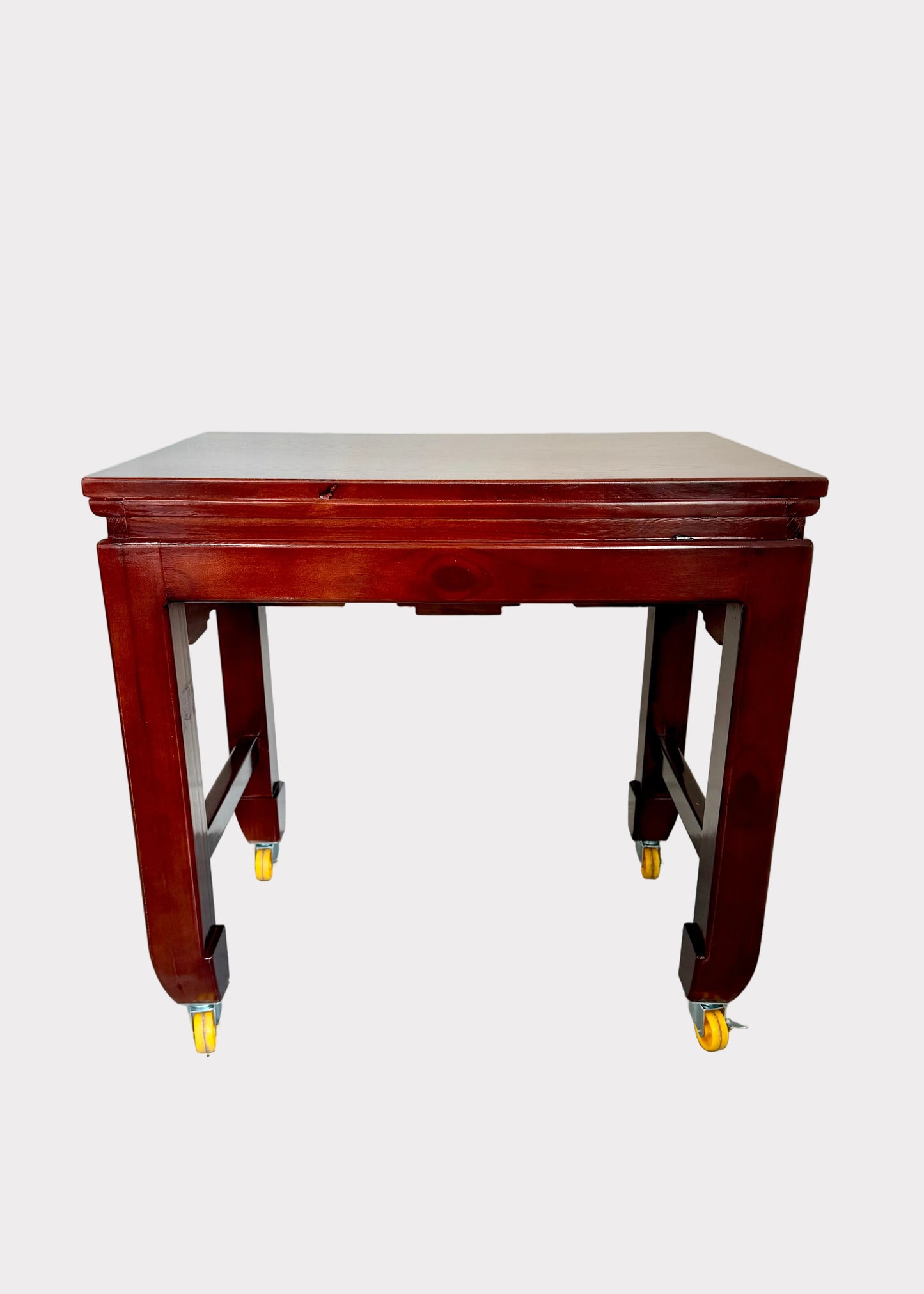 A reddish-brown wooden table with casters on the legs, shown against a plain light gray background.