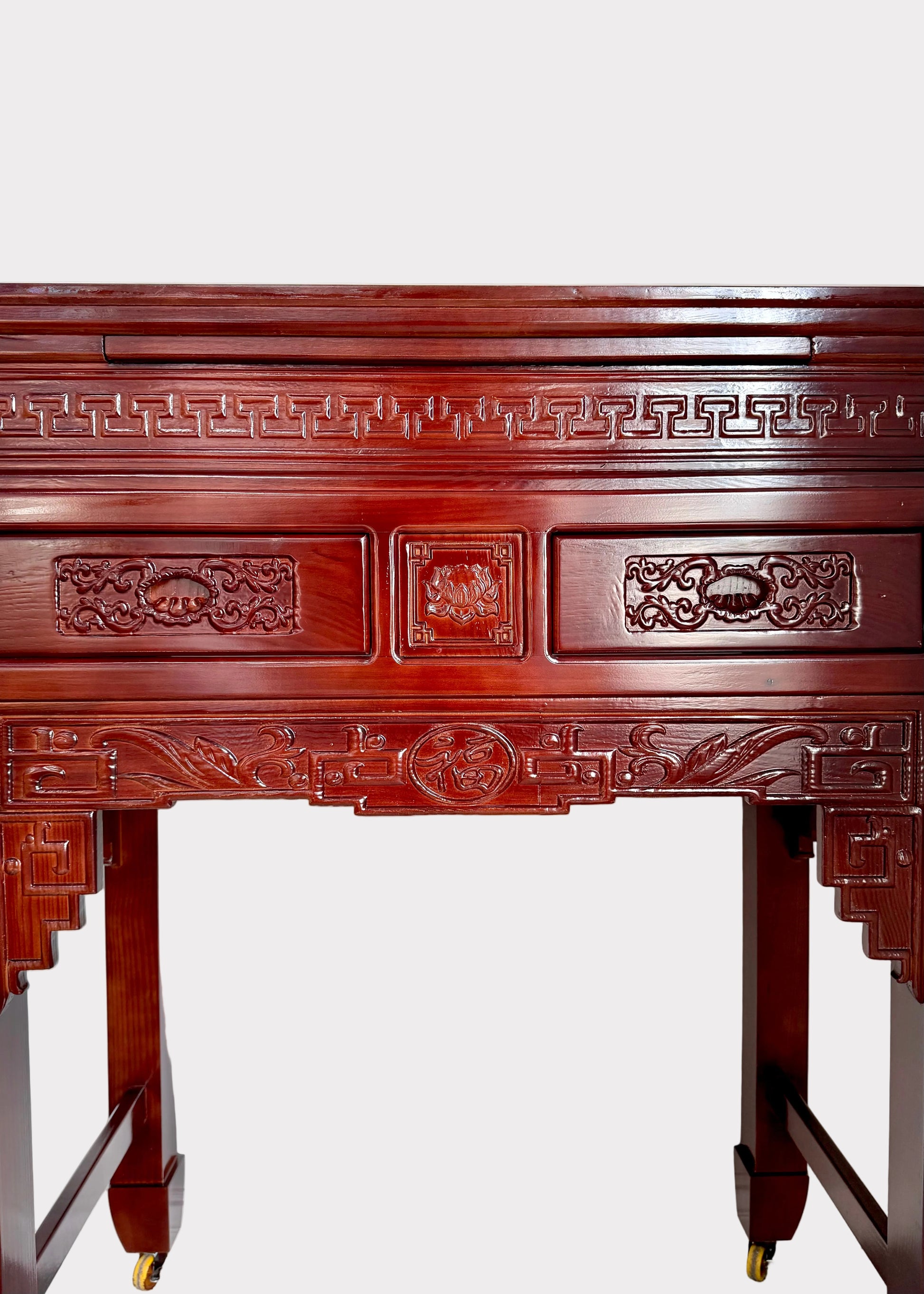 An ornate reddish-brown wooden mantel or console table with intricate hand-carved floral and geometric patterns, shown against a plain white wall.