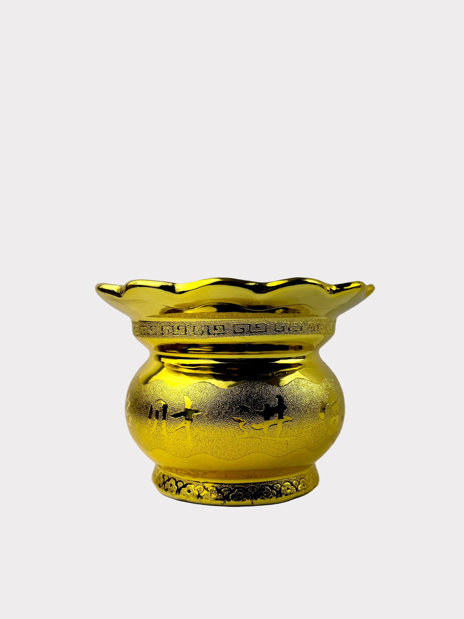 A shiny gold decorative vase with a flared scalloped rim and embossed floral details, set against a plain light gray background.