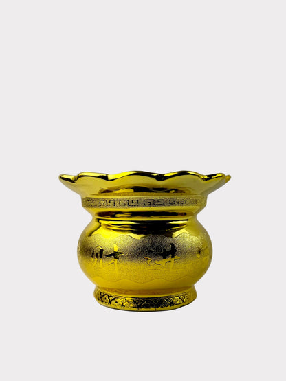 A shiny gold decorative vase with a flared scalloped rim and embossed floral details, set against a plain light gray background.