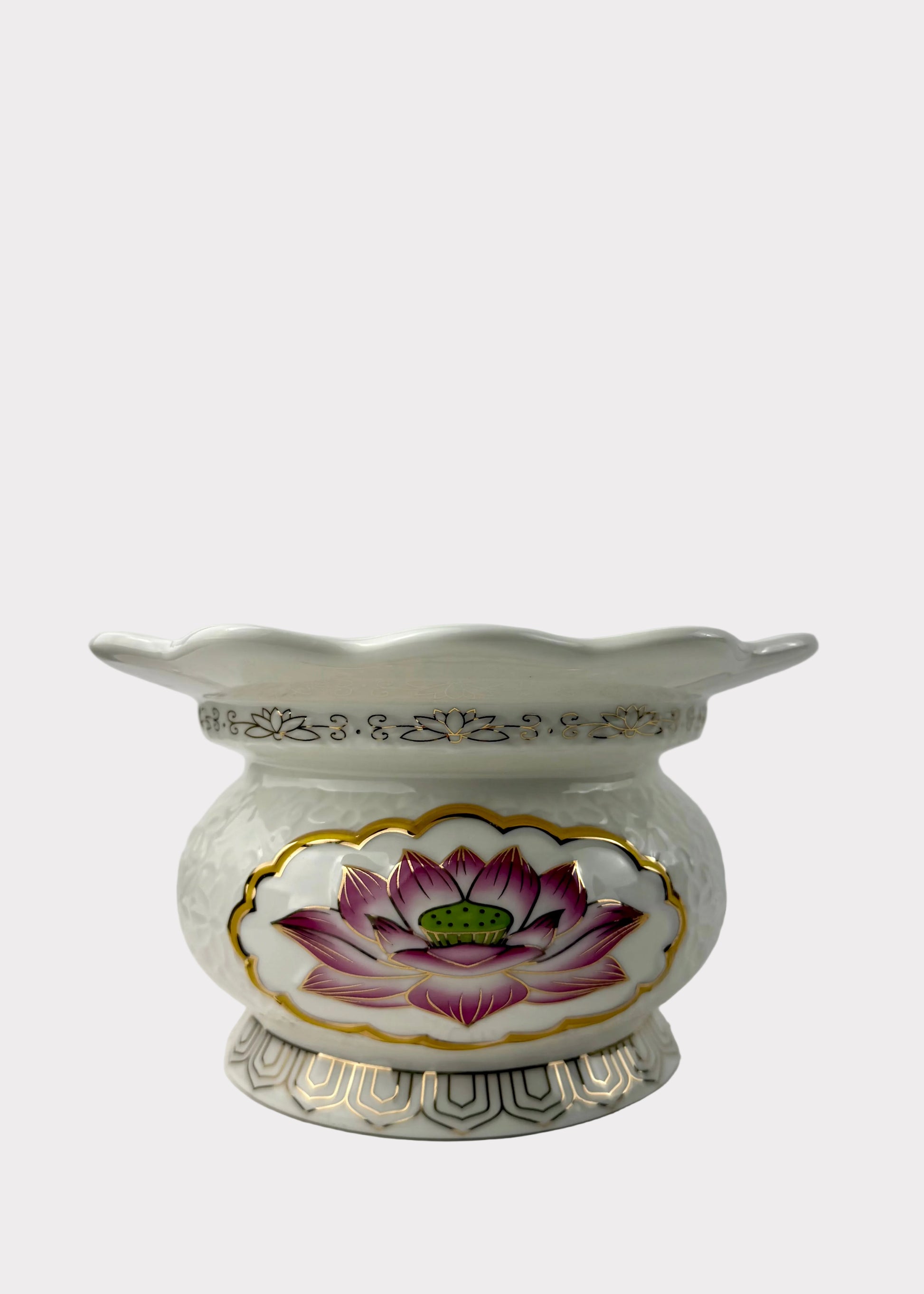 A white ceramic flower pot with a scalloped rim, featuring a hand-painted pink and purple lotus flower with a green center on the front, accented with gold trim.