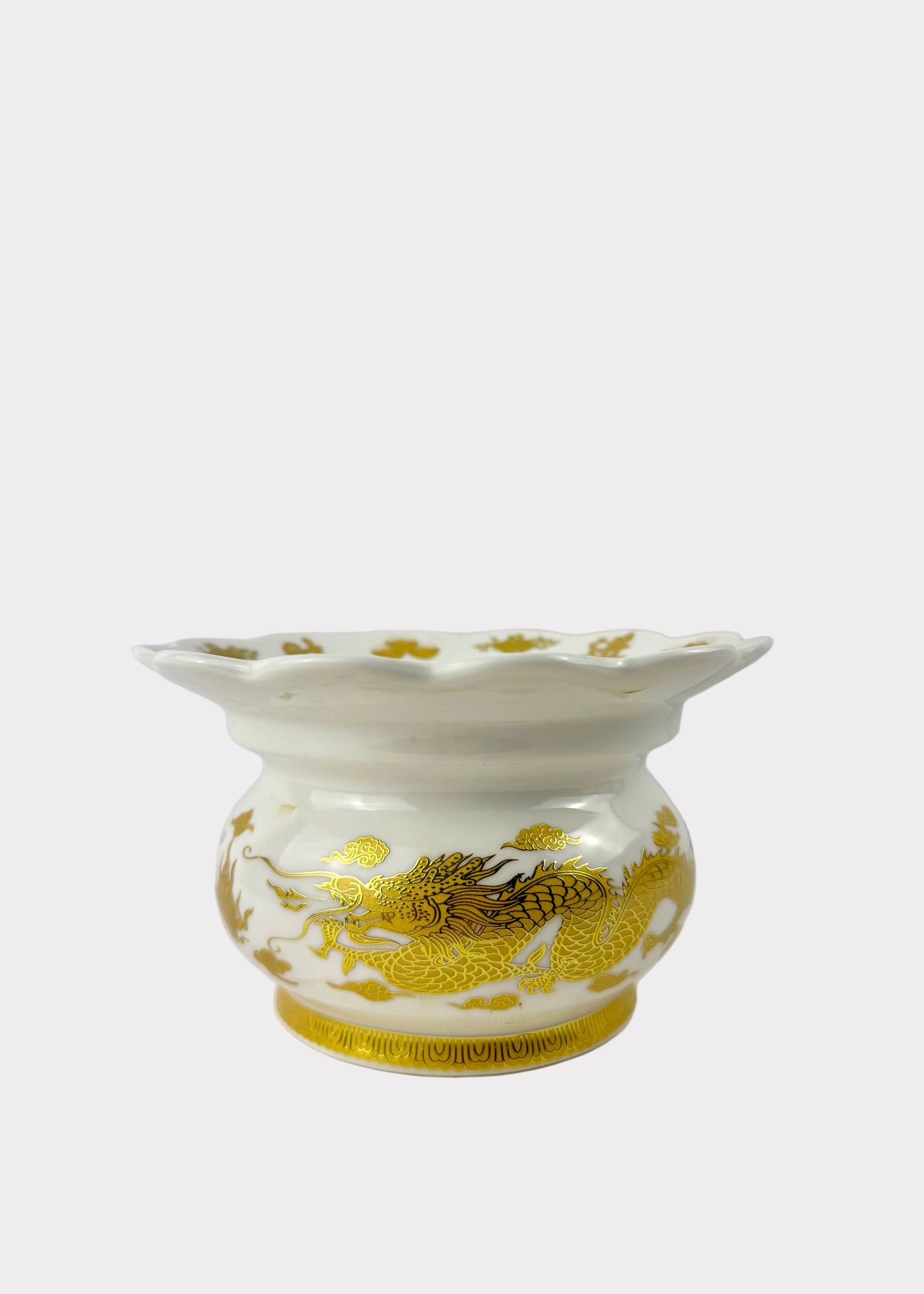 A white ceramic flower pot with a fluted rim, decorated with a gold dragon motif on the front and gold accents around the base, set against a plain light gray background.