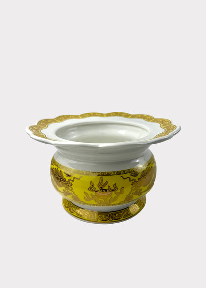 A white porcelain incense burner with a yellow and gold dragon-patterned body and a scalloped rim, set against a plain white background.