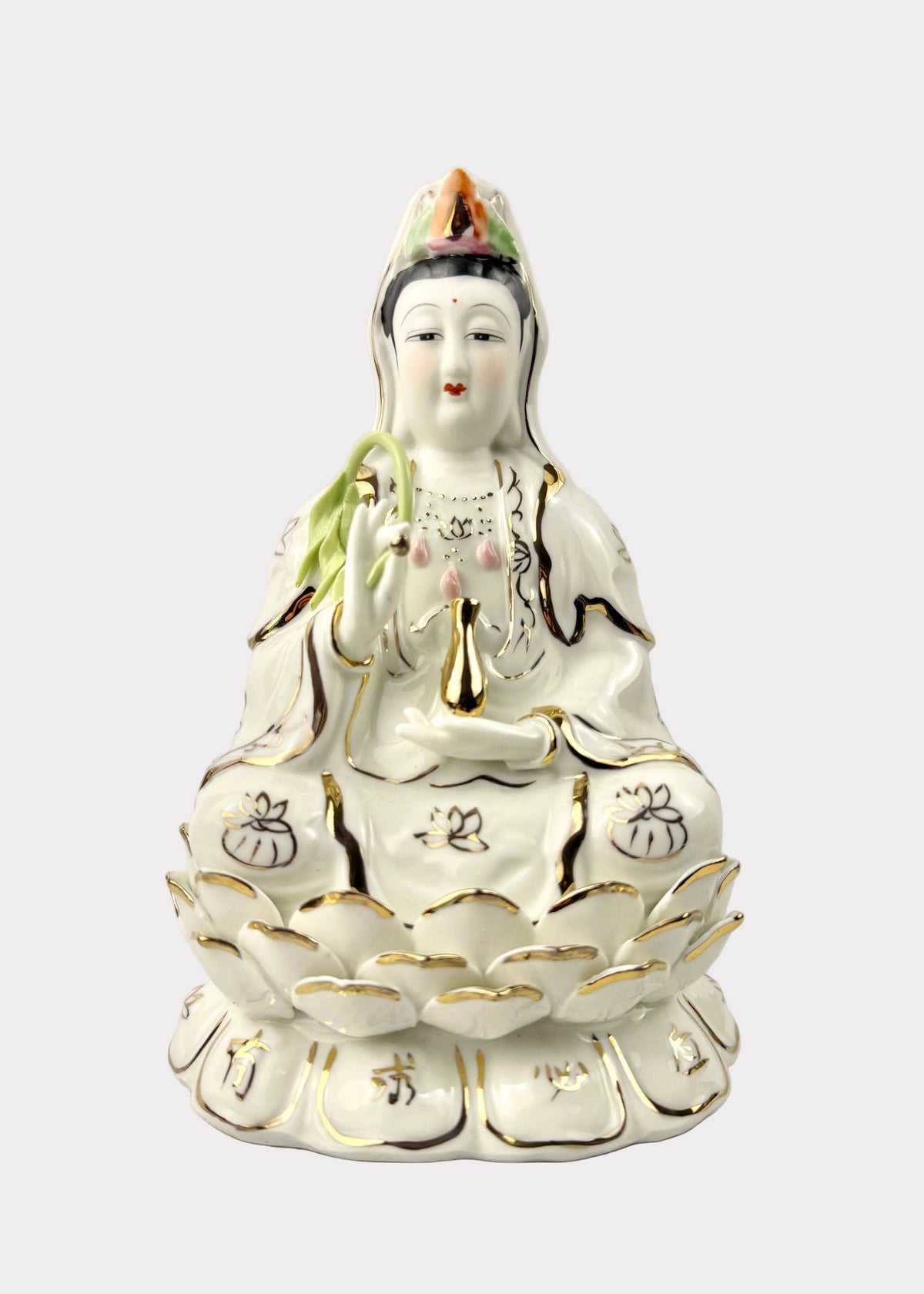 A white porcelain figurine of Guanyin seated on a lotus base, decorated with gold trim and small multicolor accents on the crown and hair, photographed against a plain light background.