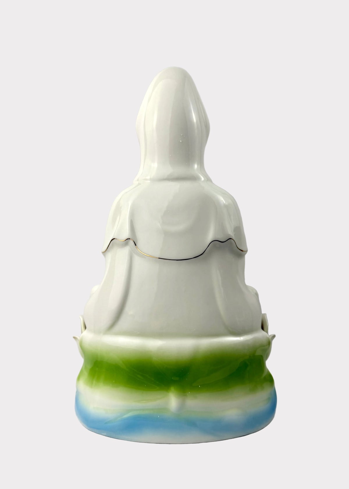 A glossy white ceramic figurine of a robed figure, likely a deity or saint, with a green and blue marbled base, photographed against a neutral light gray background.