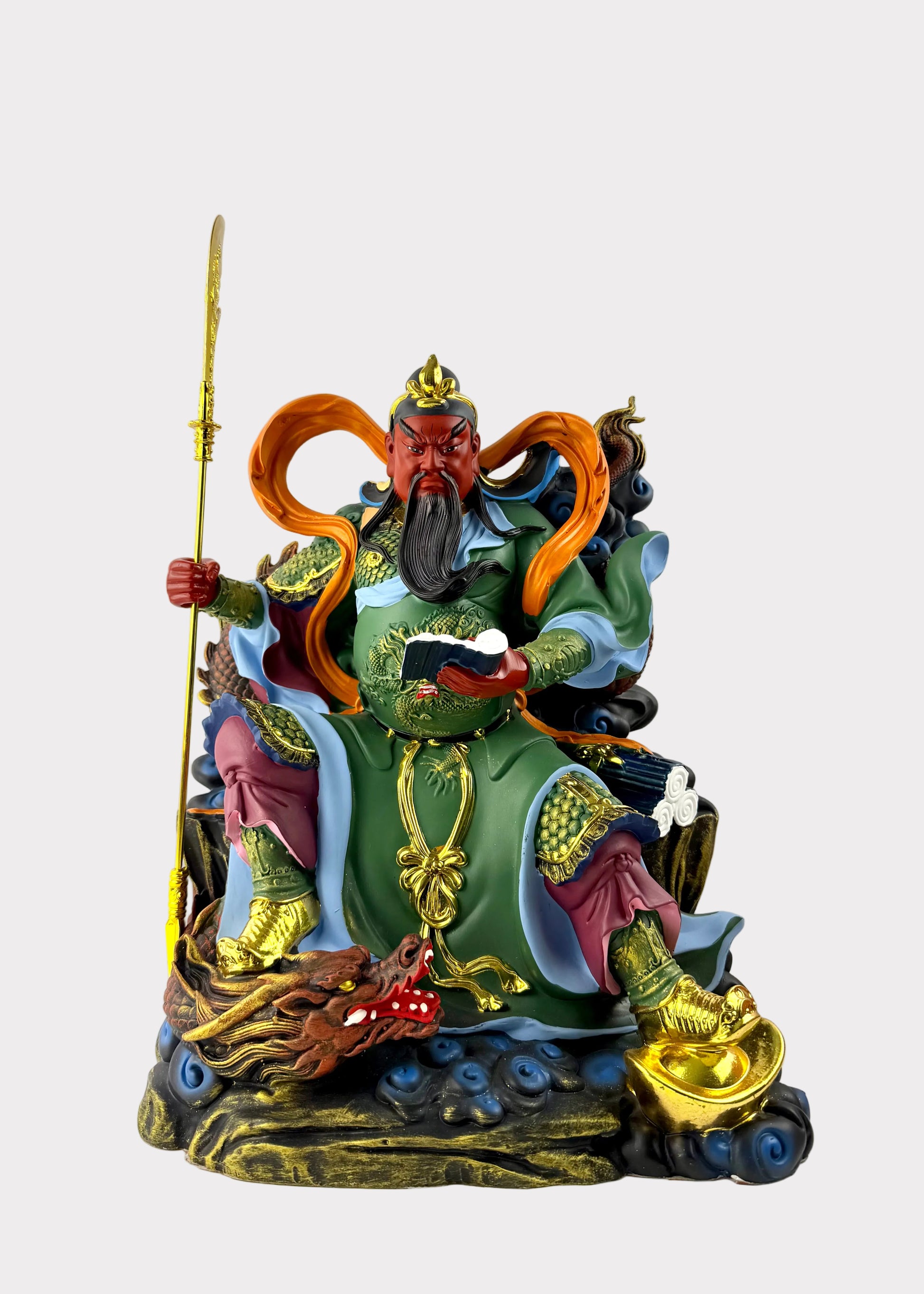 A colorful Chinese deity statue of Guan Zong seated on a cloud base, holding a spear and scroll, with green, gold, orange, and blue details against a plain white background.