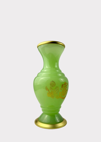 A small translucent light green vase with gold trim at the rim and base, featuring a gold dragon design on the front, set against a white studio backdrop.
