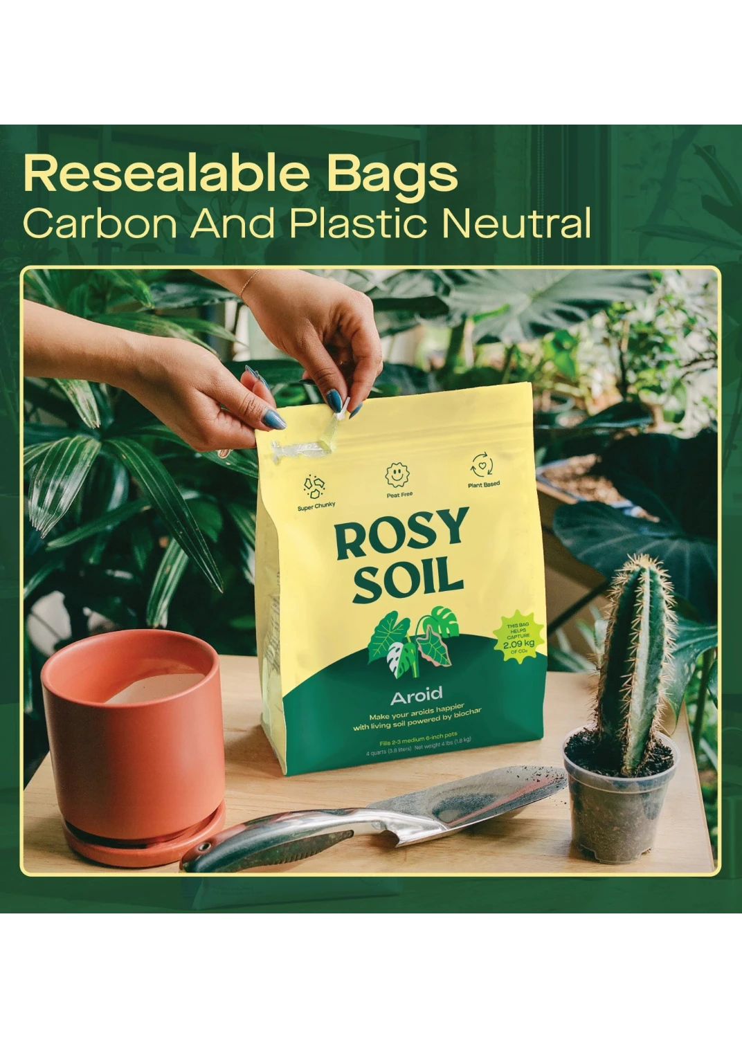 Rosy Soil packaging with hands holding it, plants in the background