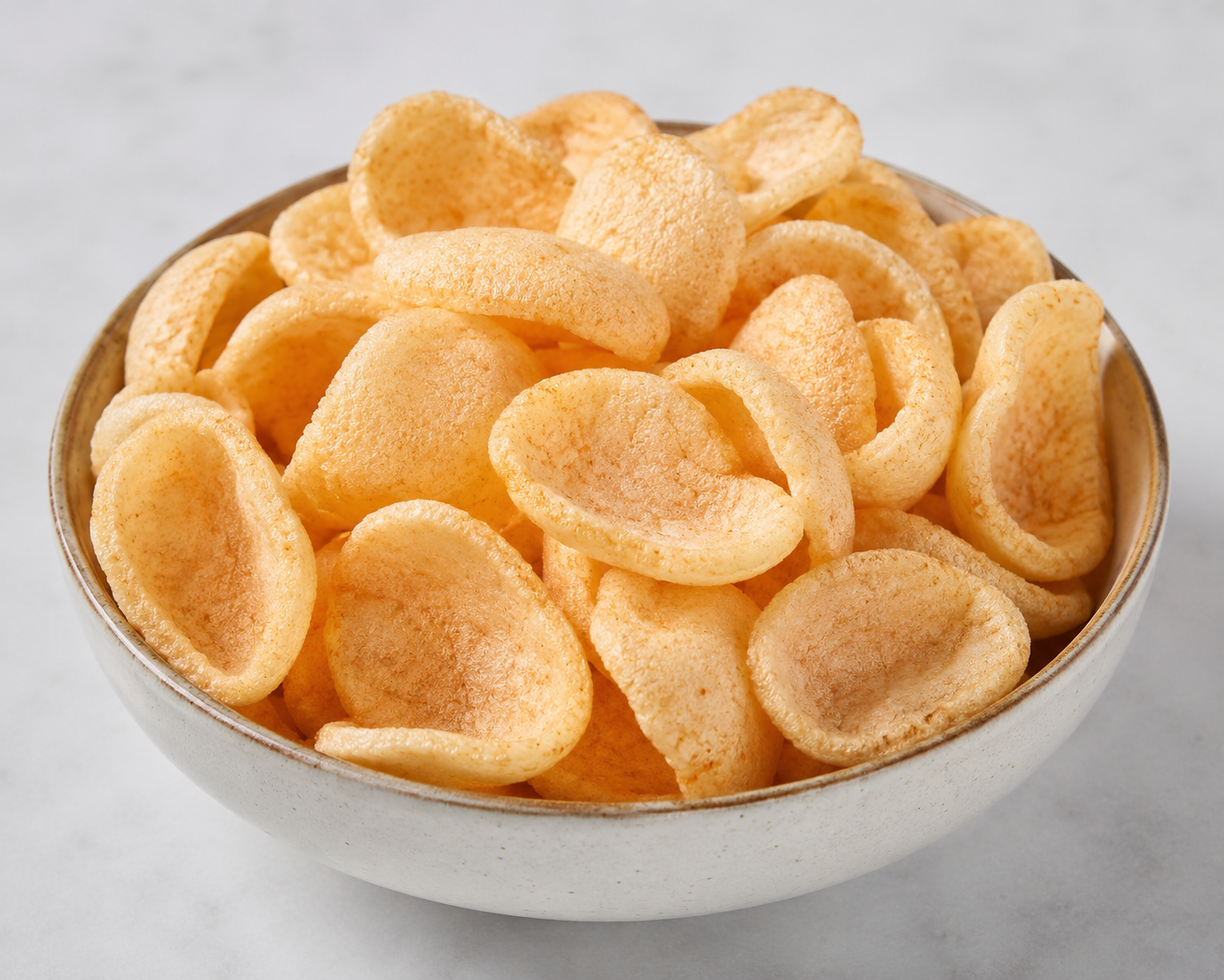 Bowl of potato chips on a light gray background