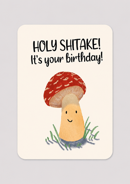 Greeting card with a mushroom illustration and text 'HOLY SHITTAKE! It's your birthday!' on a light gray background.