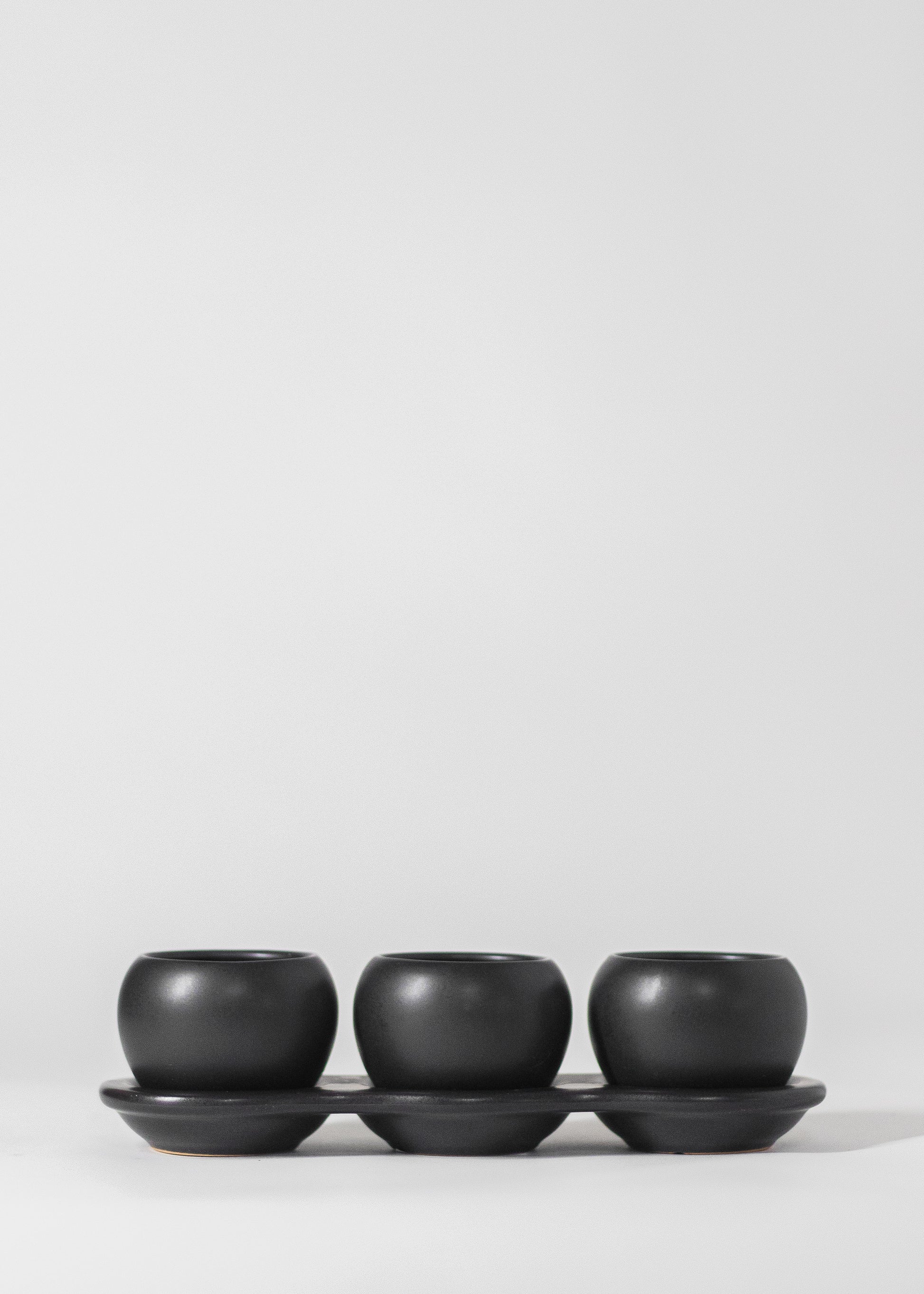 three planters on saucer in black. each planter has a 2" opening