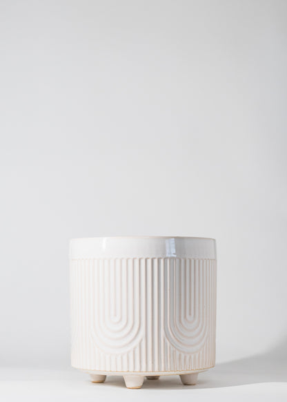footed planter with U pattern embossed into white glazed ceramic