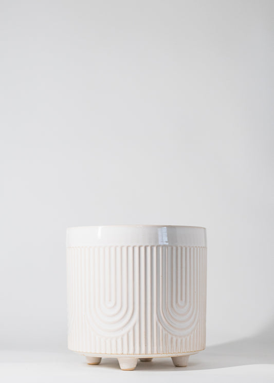 footed planter with U pattern embossed into white glazed ceramic