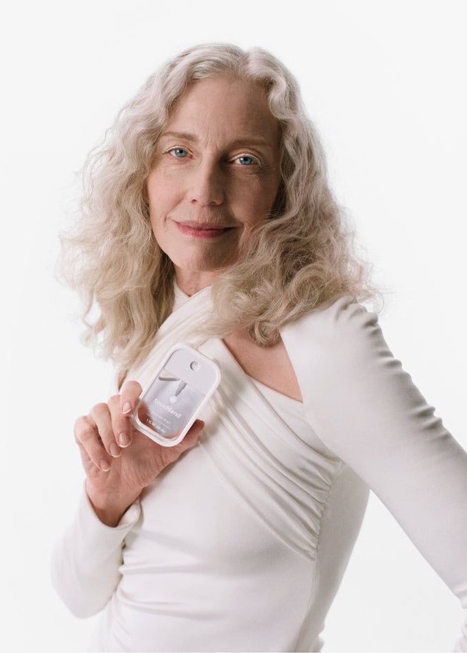 Woman holding a small electronic device against a white background