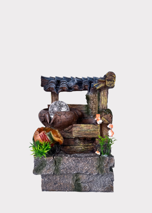 Rustic well tabletop fountain with shingled roof, wooden beams, and glowing crystal ball - front view - Rainbow Rosemead